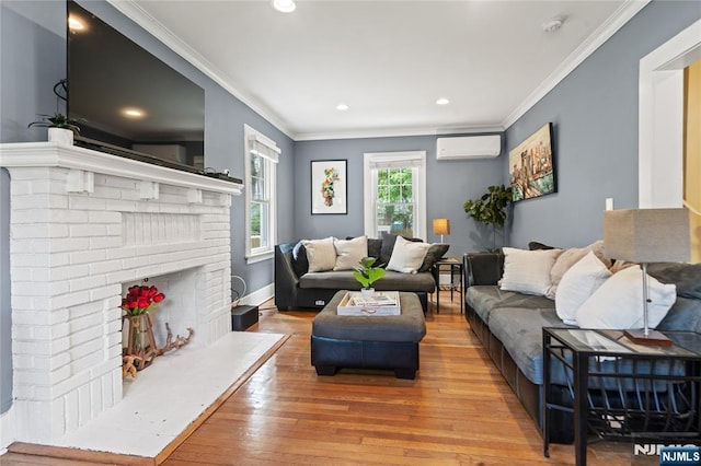 living area featuring ornamental molding, a fireplace, an AC wall unit, recessed lighting, and light wood-type flooring