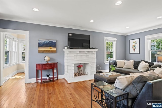 living area featuring crown molding, recessed lighting, baseboards, and hardwood / wood-style floors