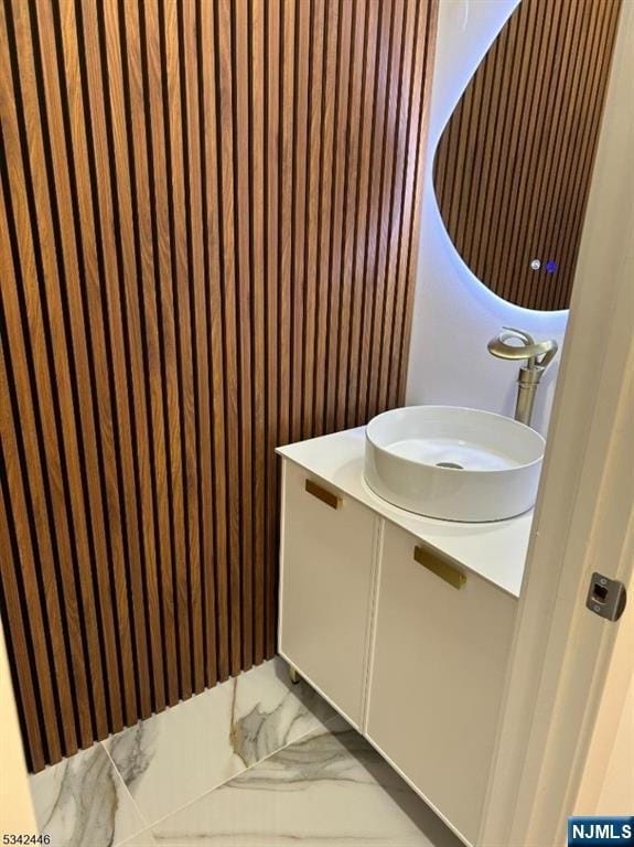 bathroom with marble finish floor and vanity