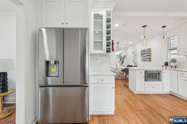 kitchen with light wood finished floors, stainless steel appliances, light countertops, white cabinets, and glass insert cabinets