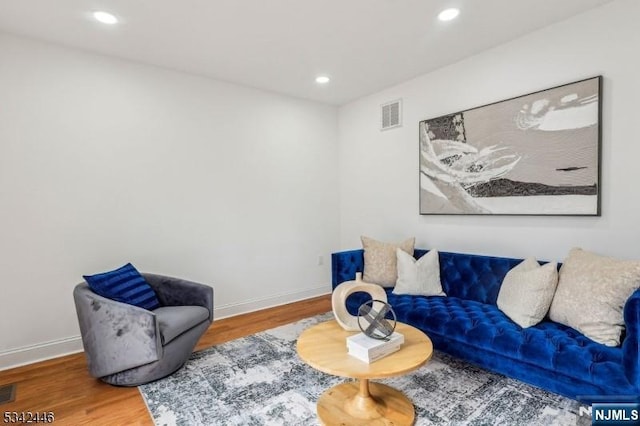 living area featuring visible vents, recessed lighting, baseboards, and wood finished floors