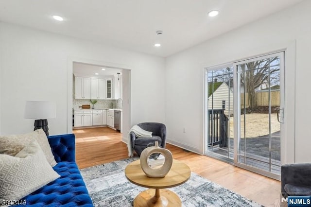 living area featuring recessed lighting, baseboards, and light wood-style flooring