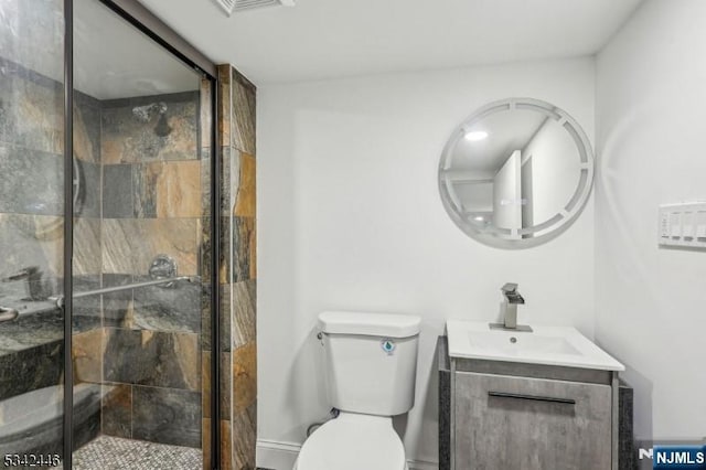 bathroom with vanity, a shower stall, and toilet