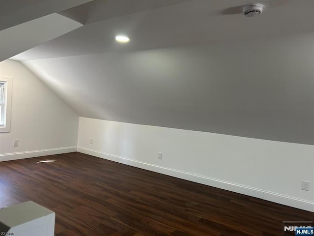 additional living space with recessed lighting, baseboards, dark wood-style flooring, and vaulted ceiling