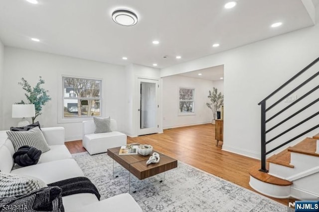 living area with stairway, recessed lighting, and light wood-style floors