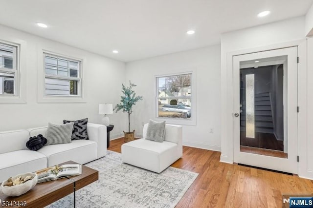 living room with recessed lighting, light wood-type flooring, and baseboards