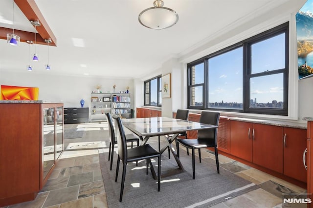 dining space with stone tile floors