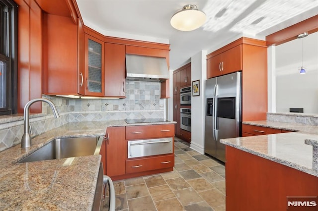 kitchen with a warming drawer, a sink, stainless steel appliances, wall chimney exhaust hood, and decorative backsplash