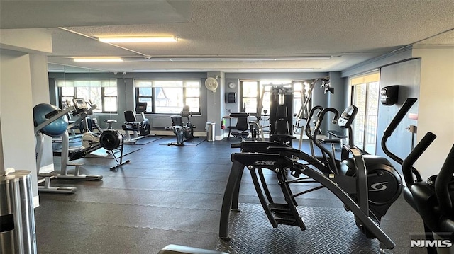 workout area with baseboards and a textured ceiling