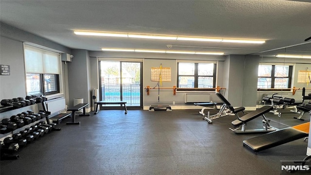 workout area featuring baseboards and a textured ceiling