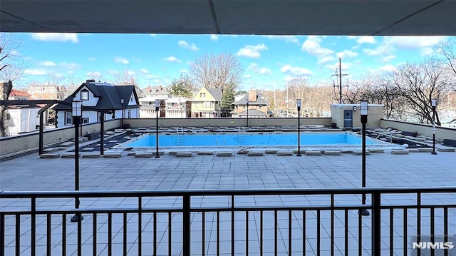 view of pool with a patio area and a residential view