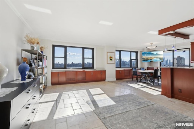 interior space with crown molding, stone tile floors, and baseboards