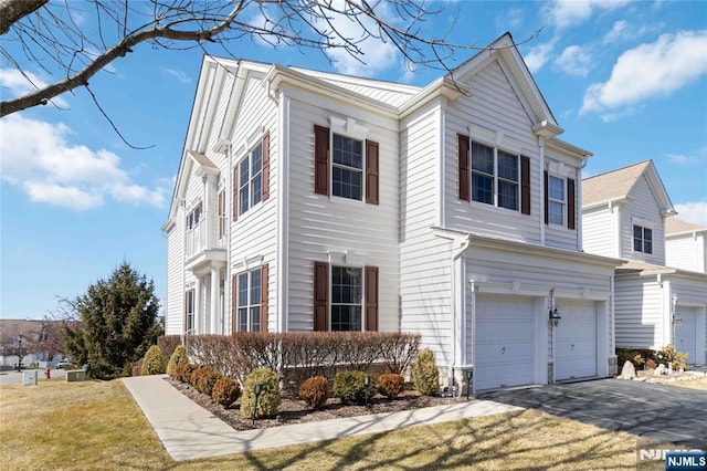 view of front of property featuring aphalt driveway, a front lawn, and a garage