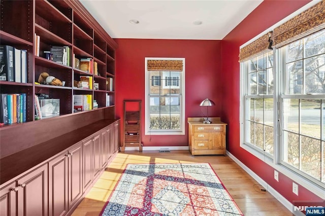 living area with baseboards and light wood finished floors