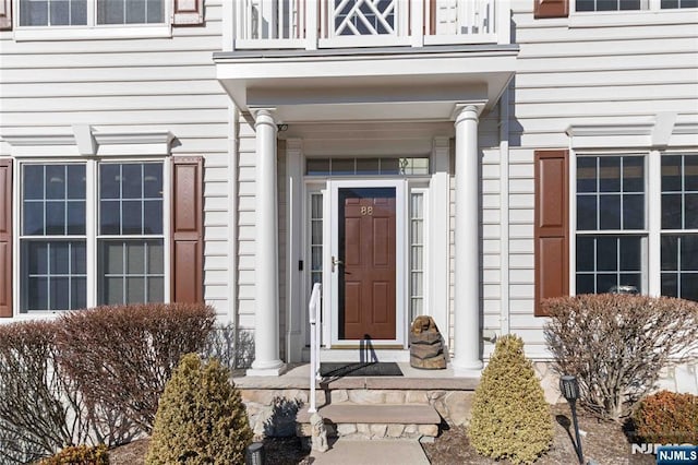 view of exterior entry with a balcony