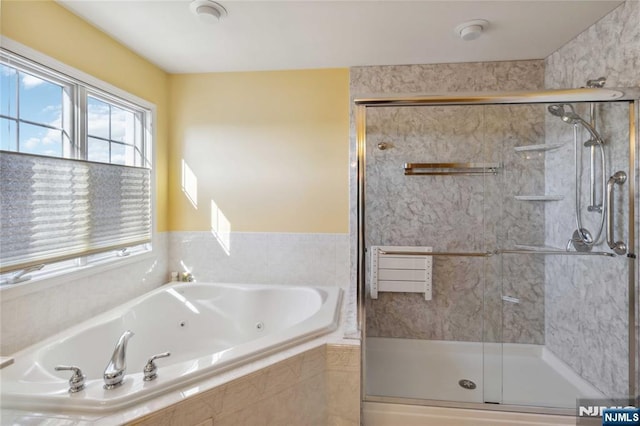 bathroom with a jetted tub and a stall shower