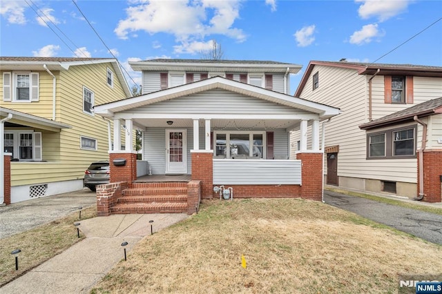 american foursquare style home with covered porch and driveway