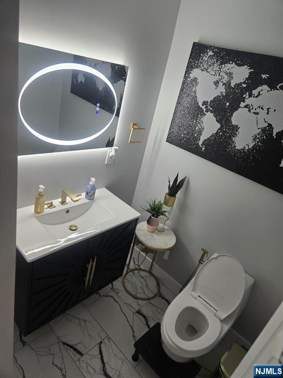 bathroom featuring marble finish floor, vanity, and baseboards