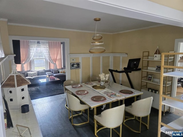 dining area with wood finished floors and ornamental molding