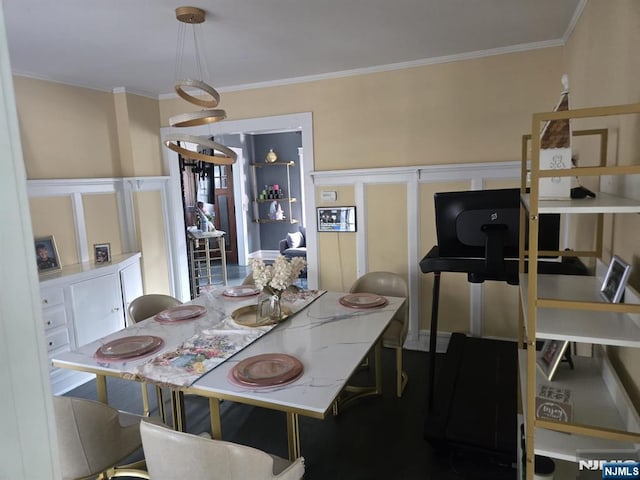 dining space featuring a wainscoted wall, a decorative wall, and ornamental molding