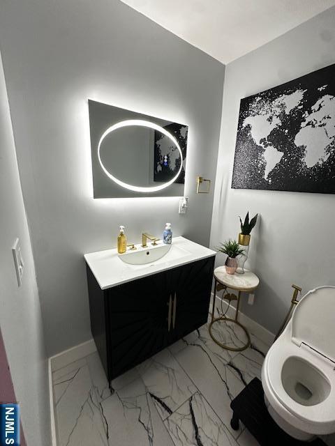 bathroom with vanity, baseboards, and marble finish floor