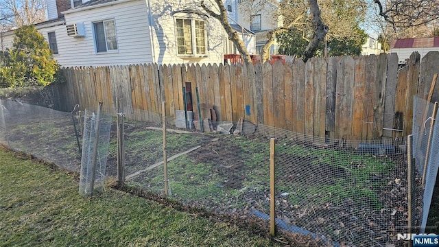 exterior space with an AC wall unit and fence