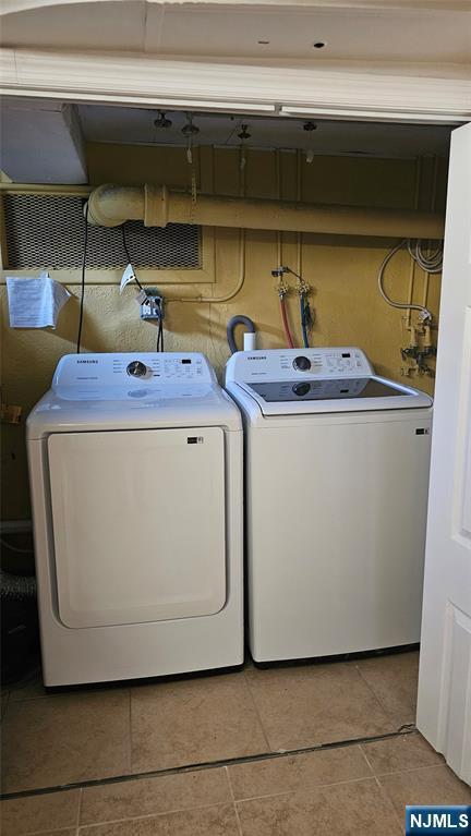 clothes washing area featuring separate washer and dryer and laundry area