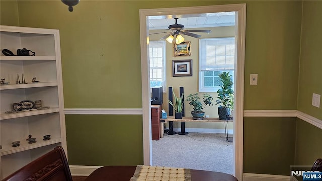 carpeted dining room with baseboards and a ceiling fan