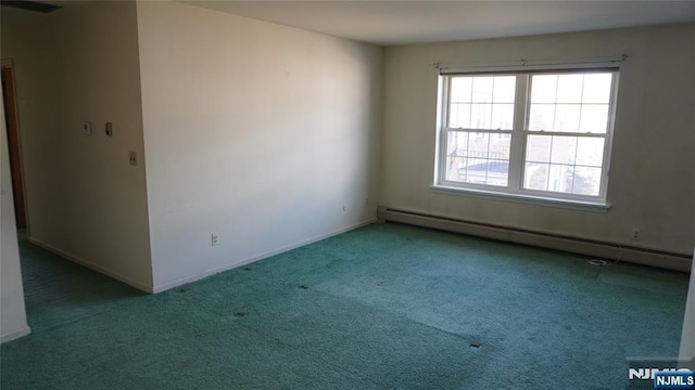 carpeted spare room featuring a baseboard heating unit and baseboards