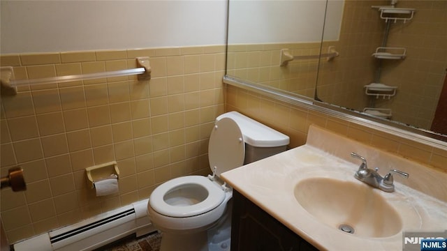 bathroom with vanity, tile walls, toilet, and a baseboard radiator