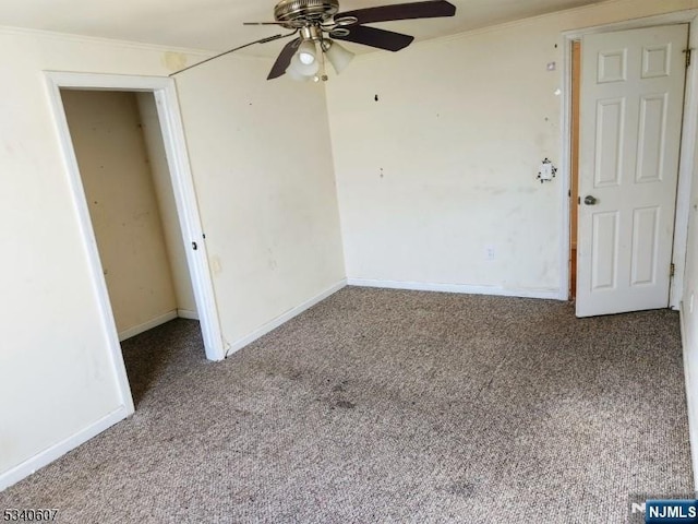 spare room with carpet flooring, ceiling fan, baseboards, and ornamental molding