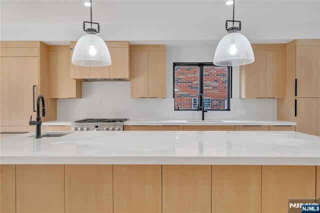 kitchen featuring modern cabinets, light brown cabinetry, and a sink