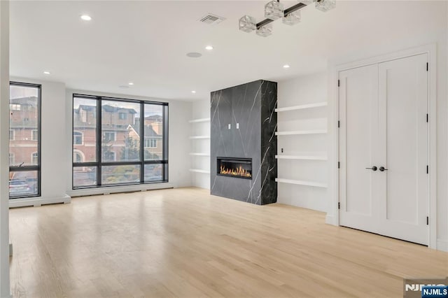 unfurnished living room featuring visible vents, recessed lighting, a fireplace, and wood finished floors