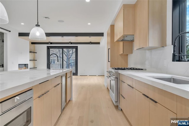 kitchen featuring light brown cabinetry, stainless steel appliances, and modern cabinets