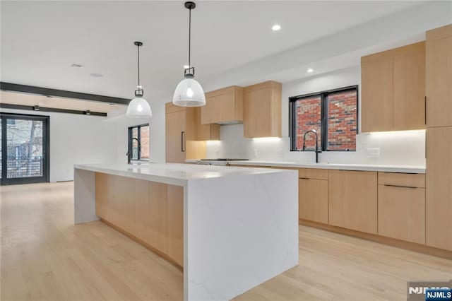 kitchen featuring light wood-type flooring, decorative backsplash, modern cabinets, and light brown cabinetry