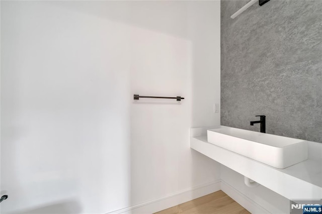 bathroom with wood finished floors and a sink