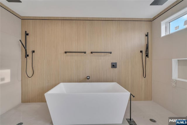 bathroom featuring tile patterned floors, tiled shower, tile walls, and a freestanding tub