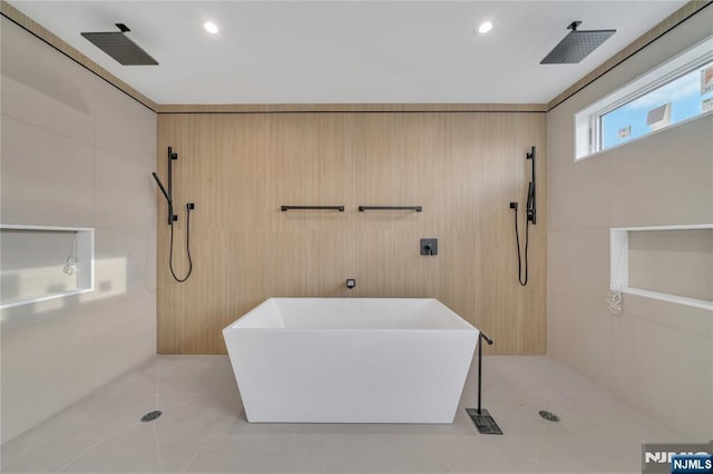 bathroom featuring a tile shower, tile patterned flooring, a soaking tub, and a sink