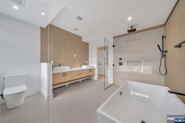 full bath with a sink, visible vents, a tile shower, and a freestanding tub