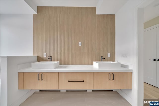 bathroom featuring tile patterned flooring, double vanity, and a sink