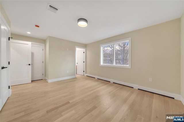 unfurnished bedroom with visible vents, light wood-type flooring, and baseboards