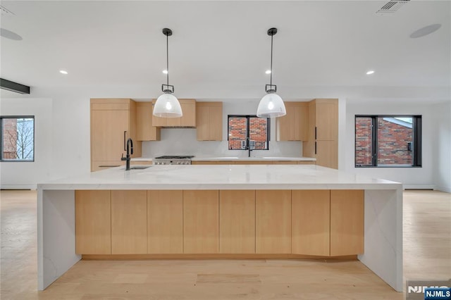 kitchen with a sink, light wood-style floors, modern cabinets, and light brown cabinetry