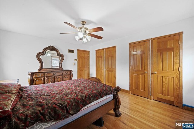 bedroom featuring a ceiling fan, visible vents, and light wood finished floors