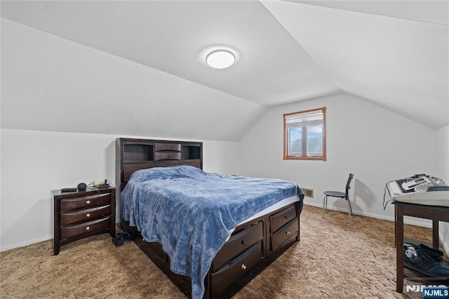 bedroom featuring lofted ceiling, baseboards, and carpet floors