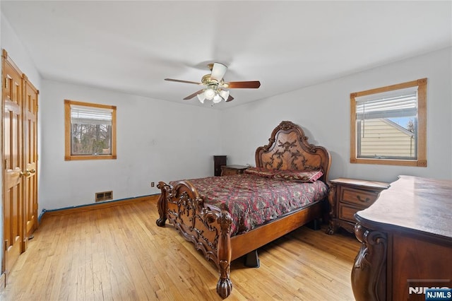 bedroom with visible vents, multiple windows, and light wood-style floors