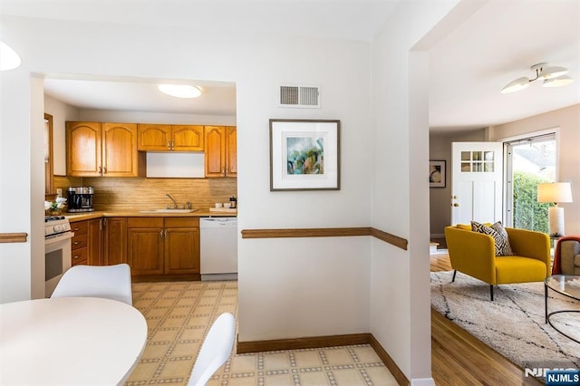 kitchen featuring white appliances, light floors, visible vents, baseboards, and decorative backsplash