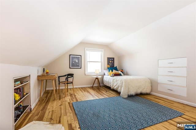 bedroom featuring vaulted ceiling, baseboards, and wood finished floors