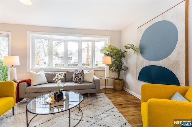 living room with plenty of natural light, wood finished floors, and baseboards