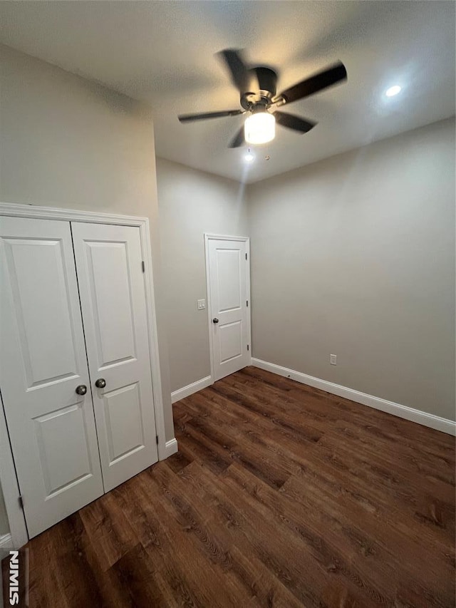 empty room featuring dark wood-type flooring, a ceiling fan, baseboards, and a textured ceiling