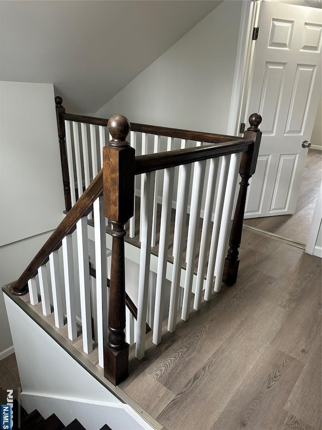 stairs with lofted ceiling and wood finished floors